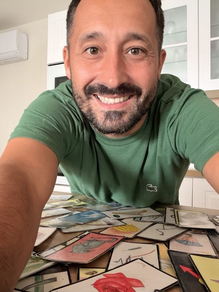 Greg, souriant, devant ses cartes étalées