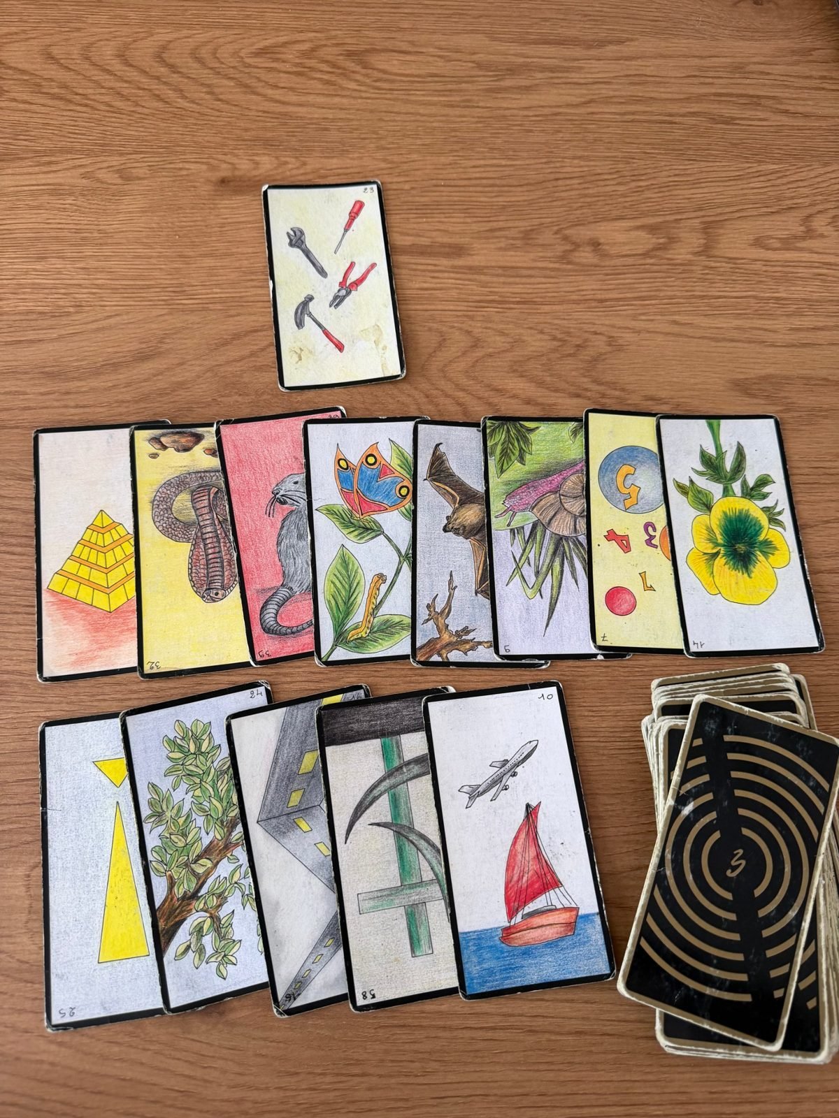 Tirage de cartes professionnel de novembre 2026 : Outils, Pyramide, Route, Bateau, Arbre et Faux, étalés sur une table en bois